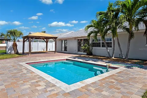 a view of a house with swimming pool and sitting area