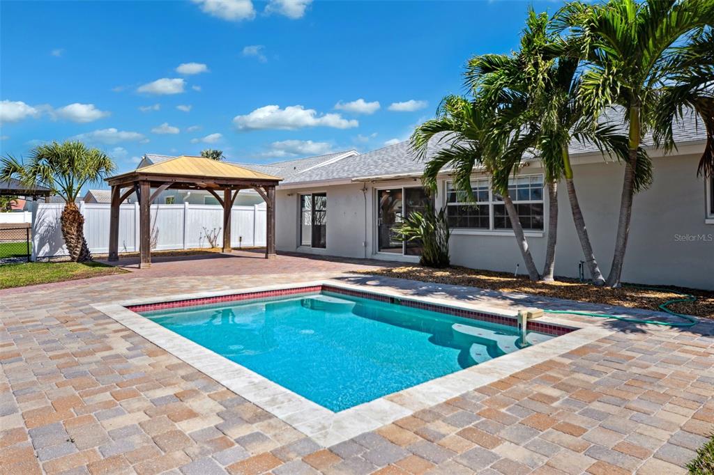 6410 3rd Palm Point St. Pete Beach, FL 33706 - Photo 16 of 54 a view of a house with swimming pool and sitting area