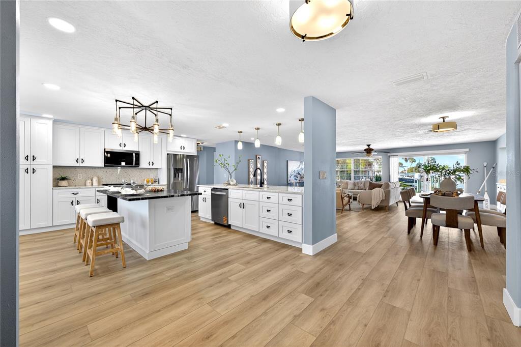6410 3rd Palm Point St. Pete Beach, FL 33706 - Photo 2 of 71 an open kitchen with wooden floor and stainless steel appliances