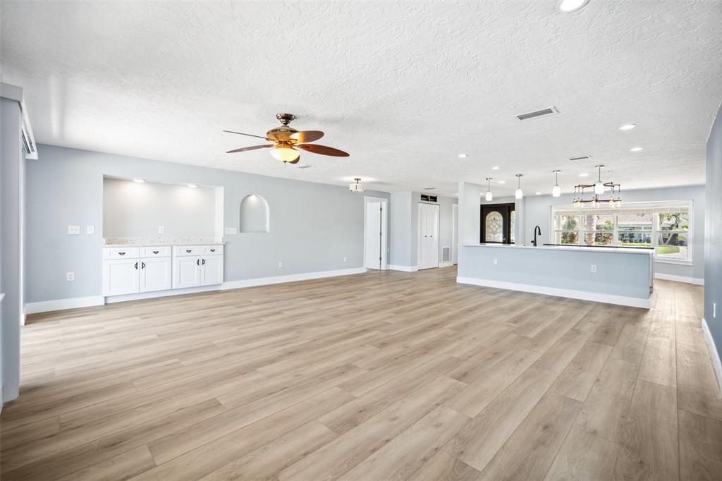 6410 3rd Palm Point St. Pete Beach, FL 33706 - Photo 21 of 54 a view of a kitchen with kitchen island a sink wooden floor and a large window