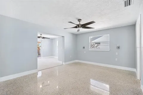 an empty room with a ceiling fan and carpet