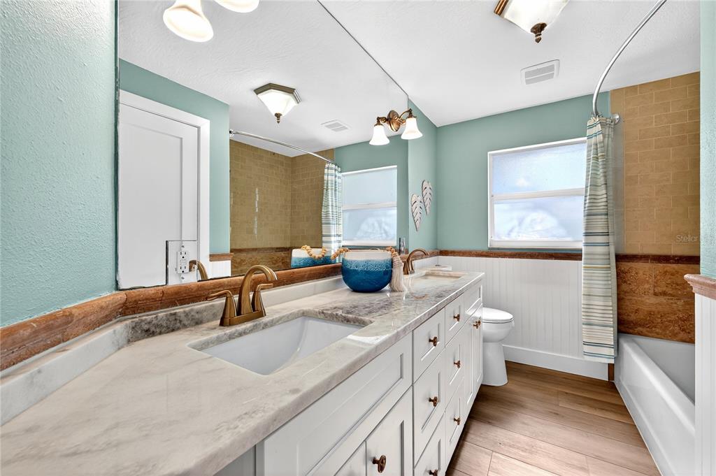 6410 3rd Palm Point St. Pete Beach, FL 33706 - Photo 29 of 71 a bathroom with a double vanity sink a mirror and a shower