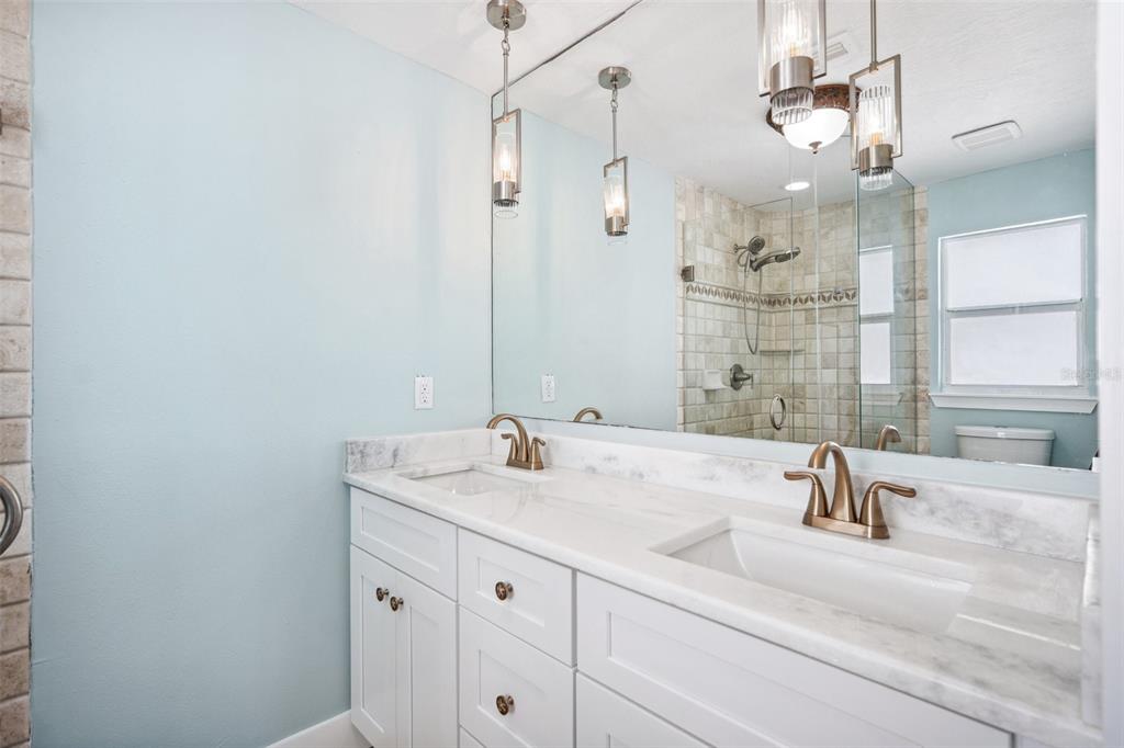 6410 3rd Palm Point St. Pete Beach, FL 33706 - Photo 32 of 54 a bathroom with a sink a double vanity and a shower