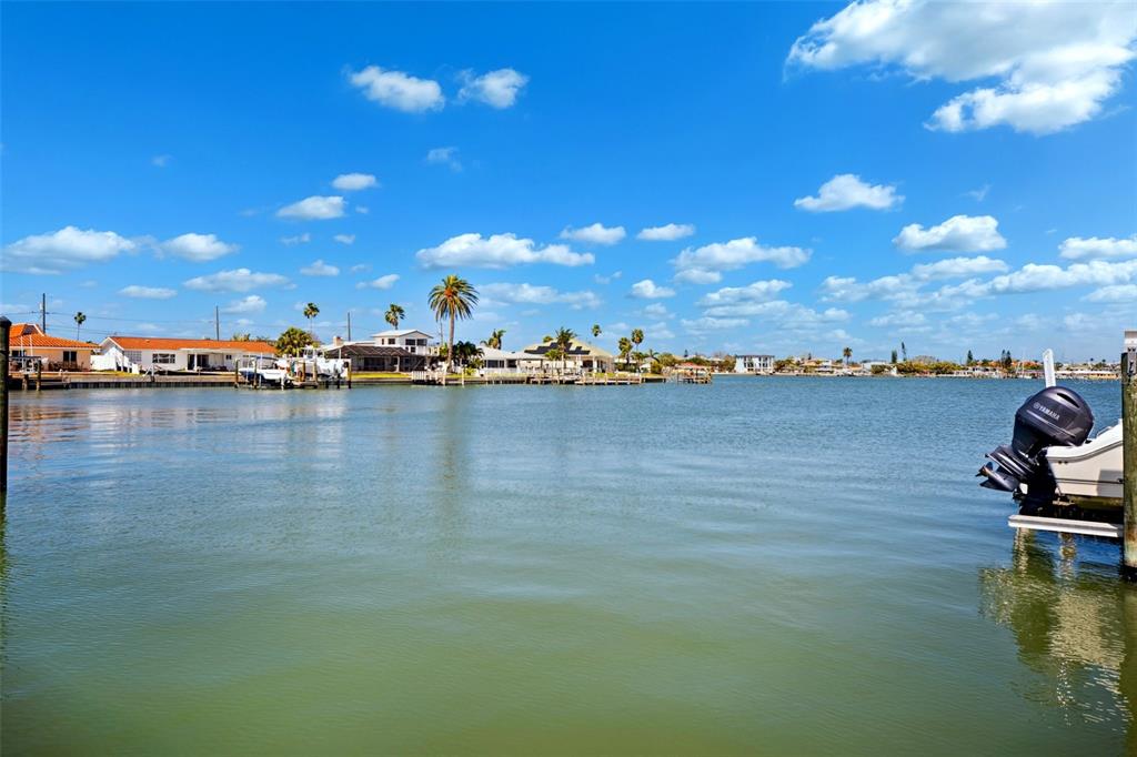 6410 3rd Palm Point St. Pete Beach, FL 33706 - Photo 33 of 71 a view of a lake with boats and trees in the background