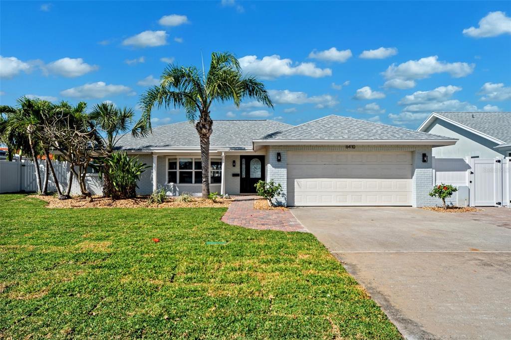 6410 3rd Palm Point St. Pete Beach, FL 33706 - Photo 43 of 54 a front view of a house with a garden and yard