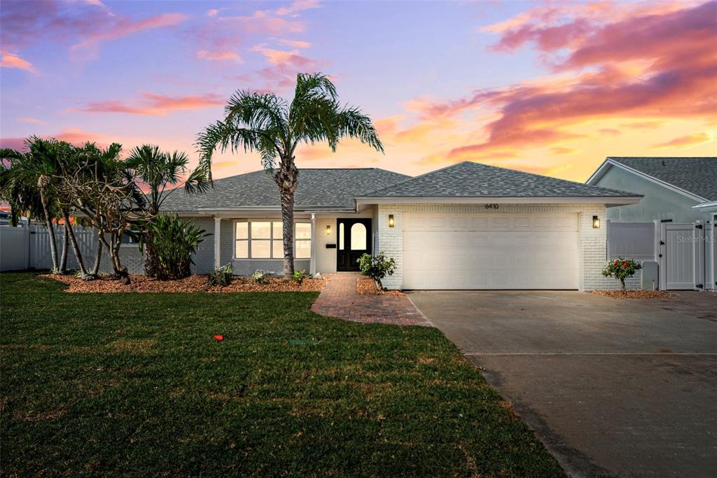 6410 3rd Palm Point St. Pete Beach, FL 33706 - Photo 51 of 71 a front view of a house with a garden and patio