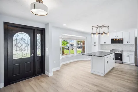 a kitchen with granite countertop a stove a sink and a refrigerator