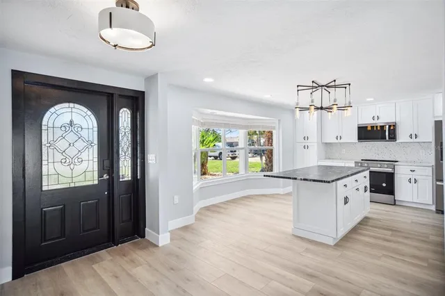 a kitchen with granite countertop a stove a sink and a refrigerator