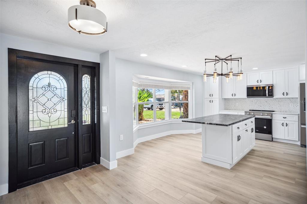 6410 3rd Palm Point St. Pete Beach, FL 33706 - Photo 6 of 54 a kitchen with granite countertop a stove a sink and a refrigerator
