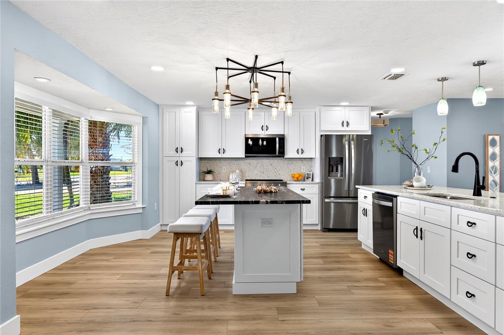 6410 3rd Palm Point St. Pete Beach, FL 33706 - Photo 8 of 71 a kitchen with stainless steel appliances a stove top oven and a refrigerator