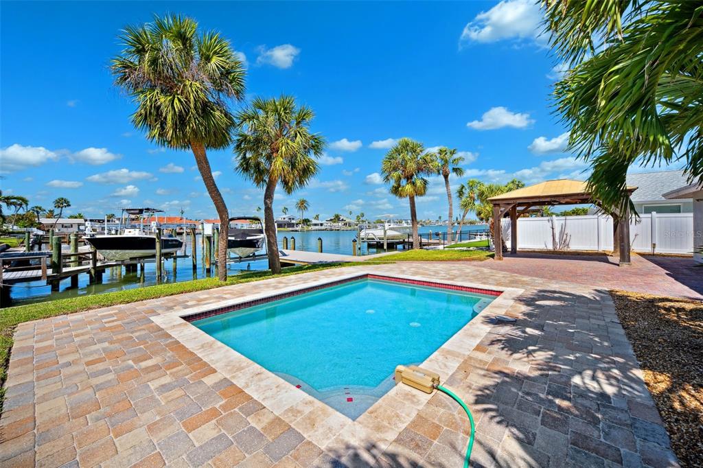 6410 3rd Palm Point St. Pete Beach, FL 33706 - Photo 9 of 71 a view of swimming pool with outdoor seating and a garden