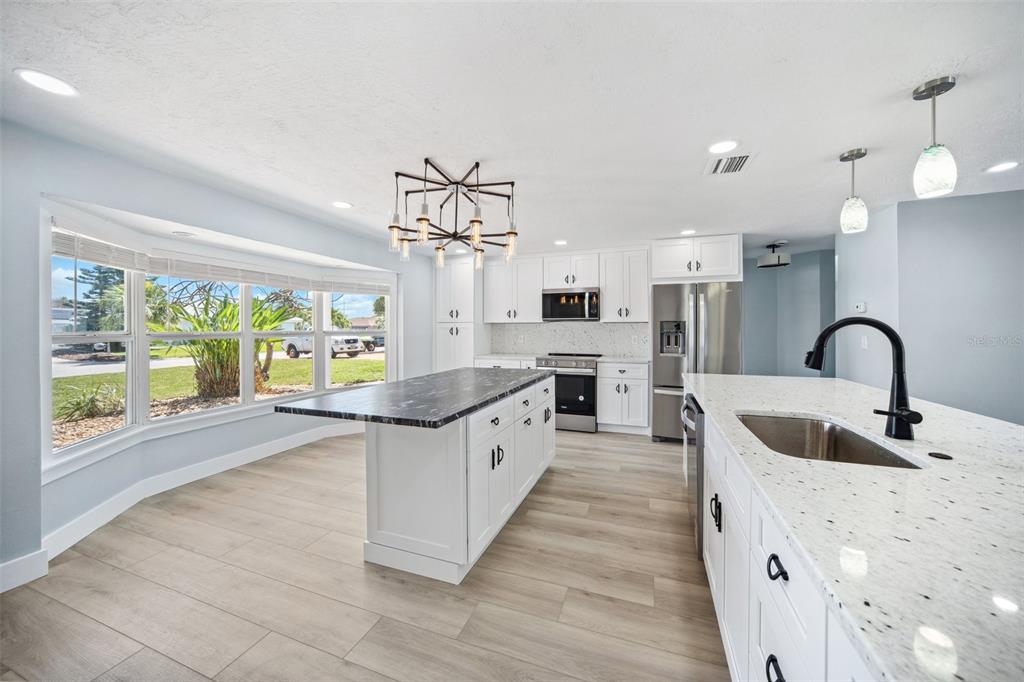6410 3rd Palm Point St. Pete Beach, FL 33706 - Photo 9 of 54 a large kitchen with granite countertop a stove a sink a refrigerator and window