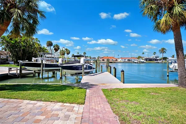 a living room with furniture kitchen view and a wooden floor