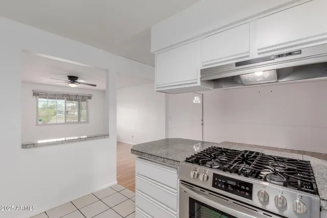 a kitchen with granite countertop a stove and a cabinets