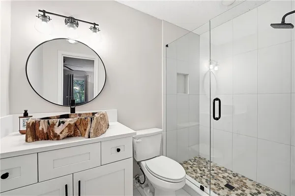 a bathroom with a sink a toilet and a mirror
