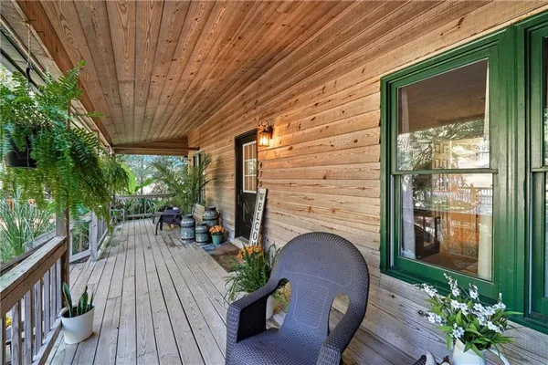 a patio with table and chairs and potted plants