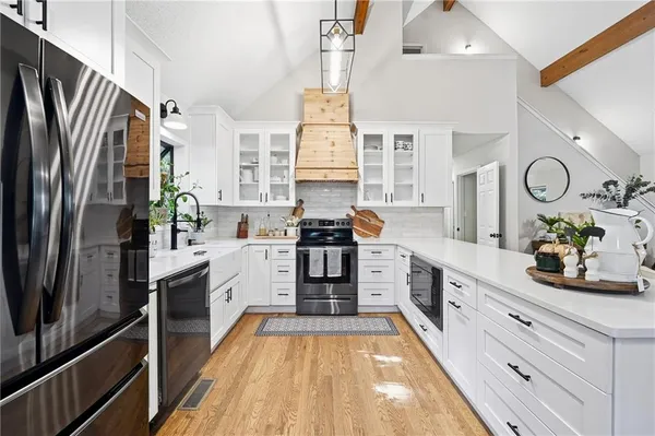 a kitchen with stainless steel appliances a refrigerator sink and white cabinets