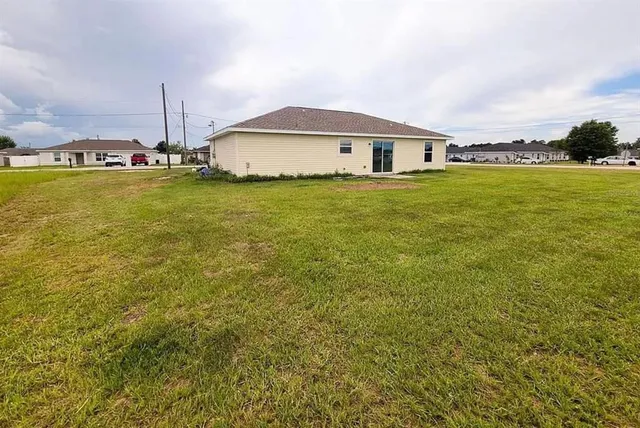 a white house with a big yard and large trees
