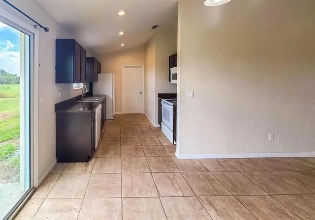 a kitchen with a sink a refrigerator and wooden cabinets