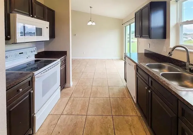 a kitchen with a sink stove top oven and cabinets