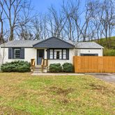 a front view of a house with yard and green space