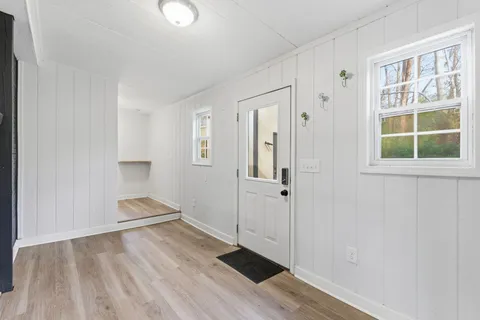 an empty room with wooden floor and windows
