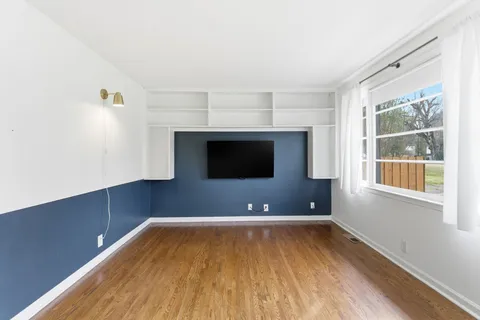 a view of room with wooden floor and fireplace