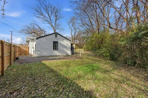 a white house that has tree in front of it