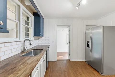 a kitchen with granite countertop a sink and a refrigerator