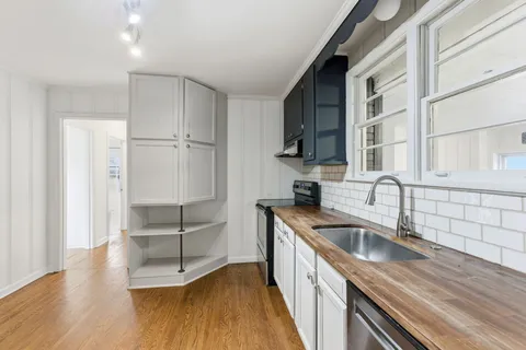 a kitchen that has a sink cabinets counter space and stainless steel appliances