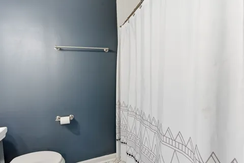 a bathroom with a toilet and a shower