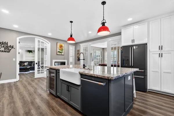 a kitchen with kitchen island granite countertop a sink a counter top space stainless steel appliances and cabinets