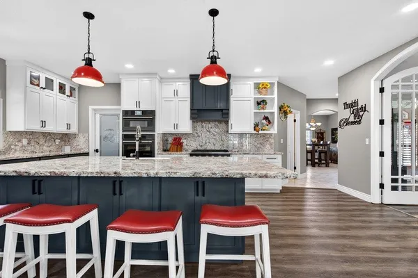 a kitchen with a sink stove and wooden floor