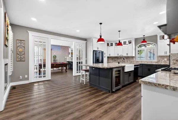 a kitchen view with wooden floor and cabinets