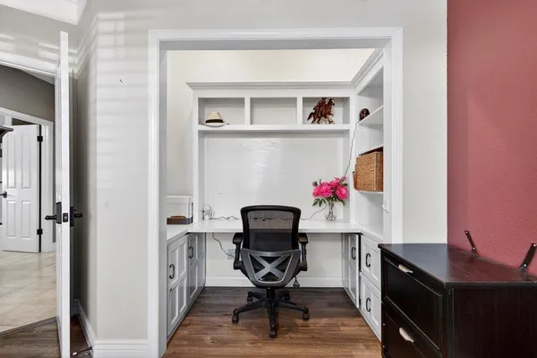 a view of a workspace with furniture and a window