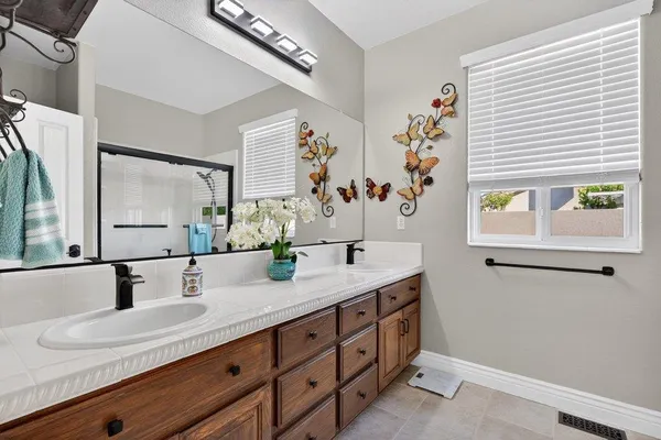 a bathroom with a granite countertop sink mirror and window