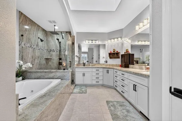 a large spacious bathroom with a granite countertop tub sink shower and mirror