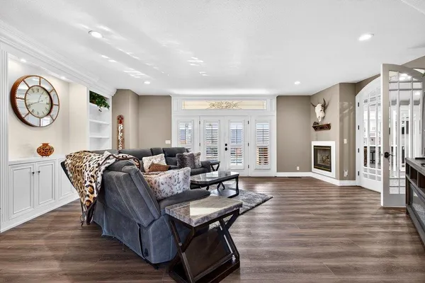 a living room with furniture a wooden floor and a large window