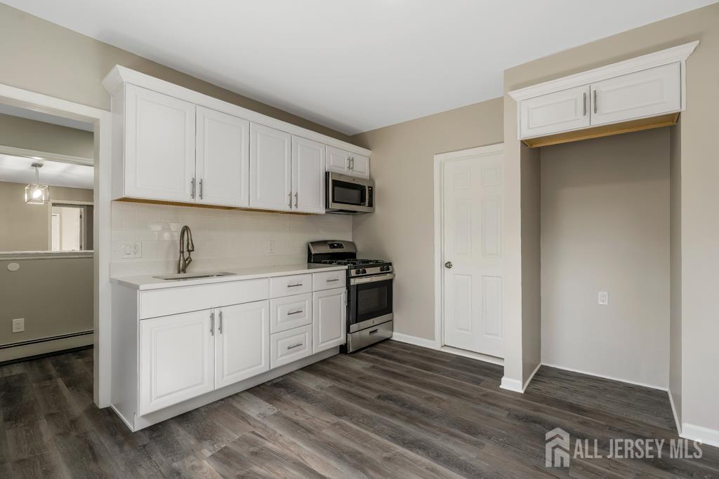 120 Chestnut Street Bridgewater, NJ 08807 - Photo 7 of 32 a kitchen with granite countertop white cabinets and stainless steel appliances with wooden floors
