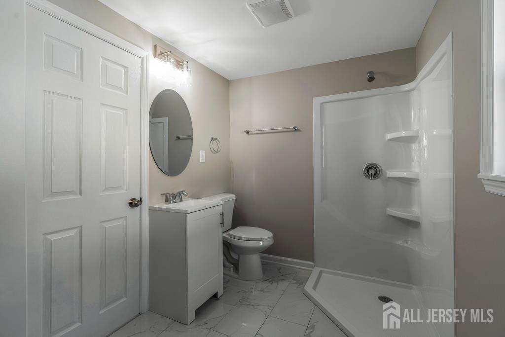 120 Chestnut Street Bridgewater, NJ 08807 - Photo 10 of 32 a bathroom with a granite countertop toilet a sink and a mirror