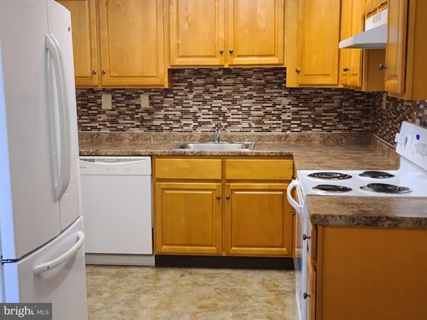 a kitchen with a sink a stove and a refrigerator