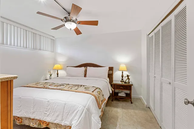 a bedroom with a bed and a lamp on the dresser