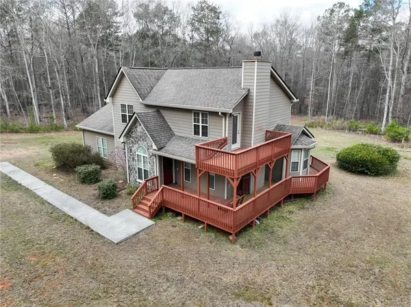 a view of a house with a yard and large tree