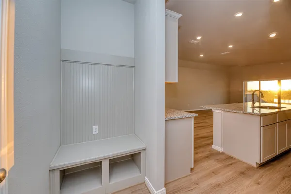 a kitchen with granite countertop white cabinets and wooden floor