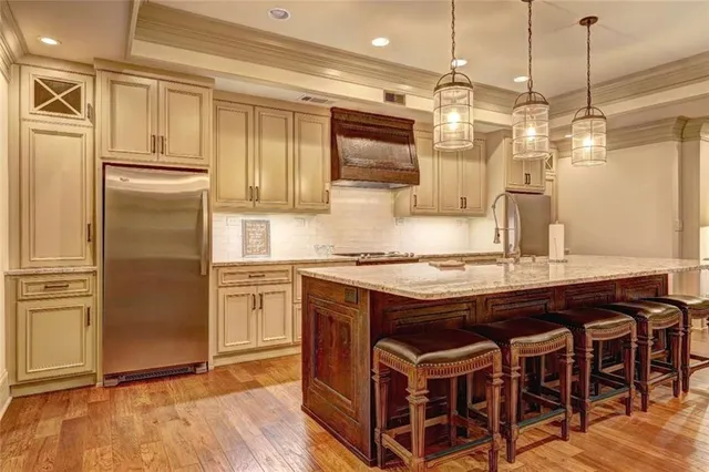 a kitchen with stainless steel appliances granite countertop a stove a refrigerator and a wooden cabinets