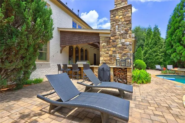a view of a patio with table and chairs potted plants and a large tree