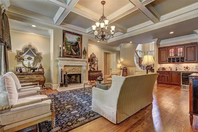 a living room with furniture a fireplace and chandelier