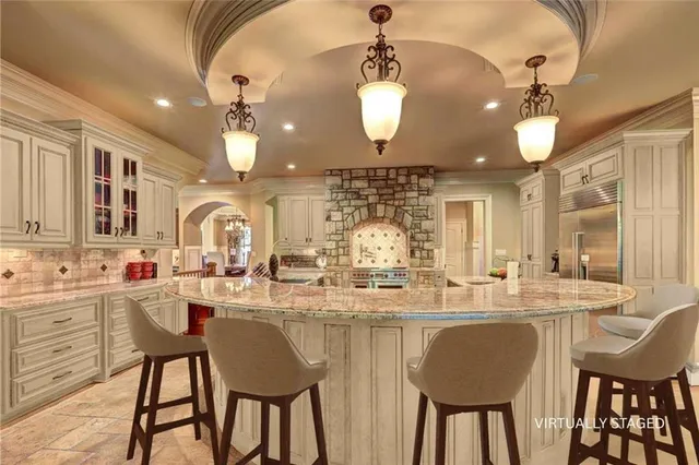 a kitchen with a dining table chairs cabinets and stainless steel appliances