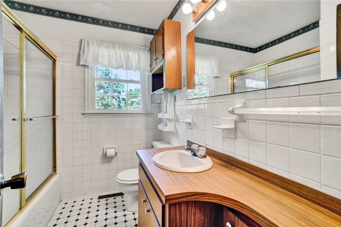 7876 Highway 11 Walhalla, SC 29691 - Photo 25 of 35 A window-filled bathroom boasts clean white tiling and a charming black-and-white patterned floor.