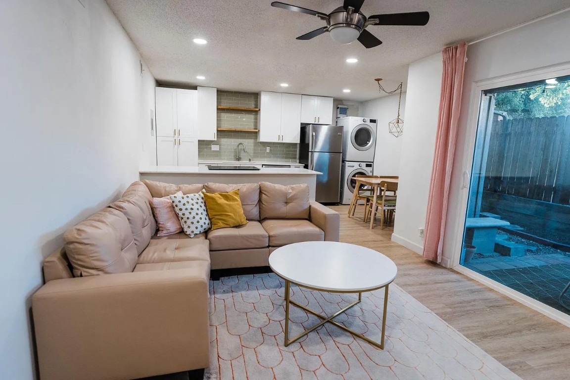 a living room with stainless steel appliances furniture a rug and a view